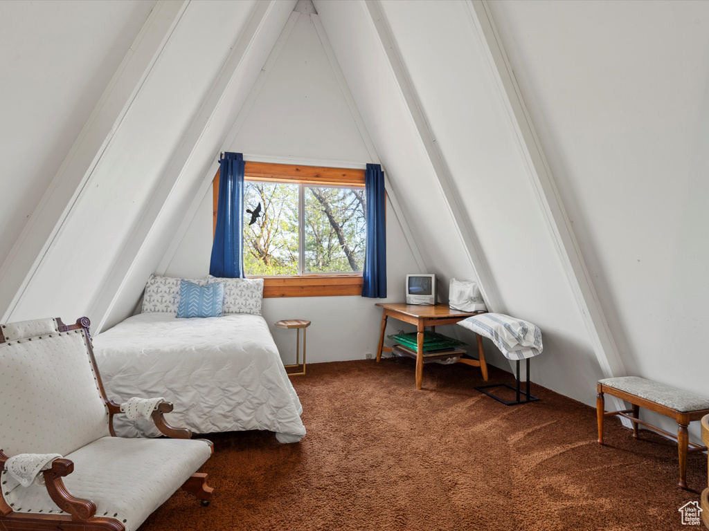 Bedroom with lofted ceiling and carpet floors