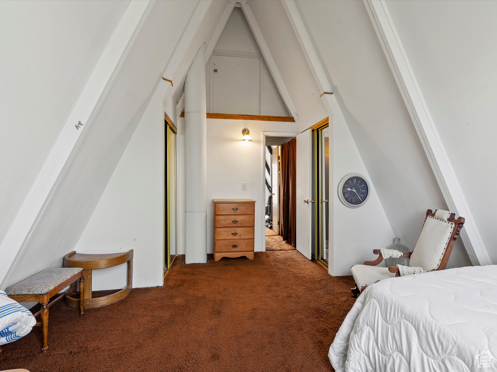 Carpeted bedroom featuring lofted ceiling