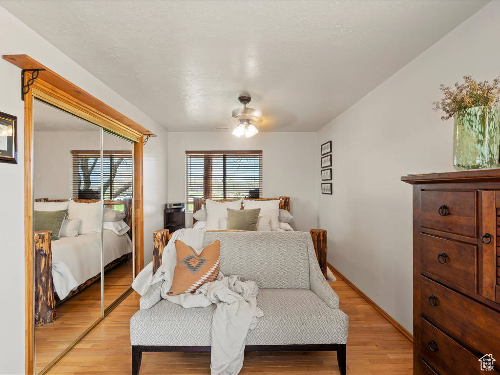 Bedroom featuring light wood-style flooring, a ceiling fan, baseboards, and a closet