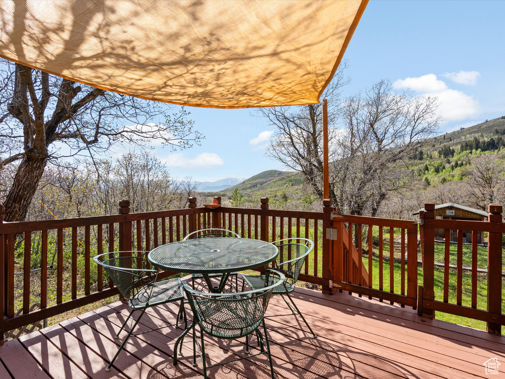 Deck with outdoor dining space and a mountain view
