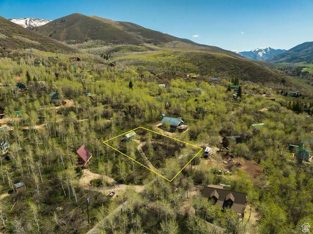 Aerial overview of property's location featuring a mountainous background and property boundaries highlighted