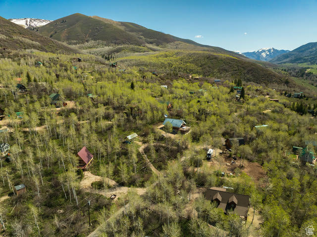 Aerial view of property and surrounding area featuring a mountainous background