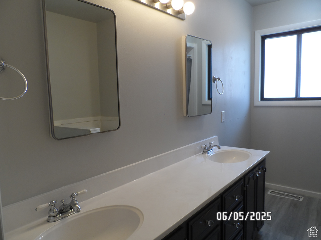 Bathroom with double vanity and baseboards