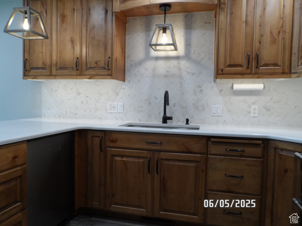 Kitchen featuring a sink, black dishwasher, and tasteful backsplash