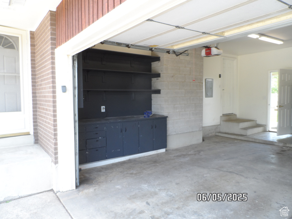 Garage with electric panel and a garage door opener
