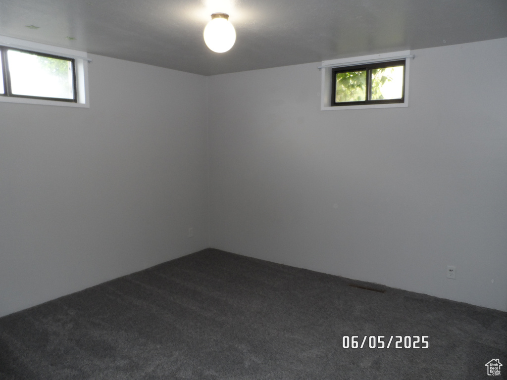 Basement with dark carpet and plenty of natural light
