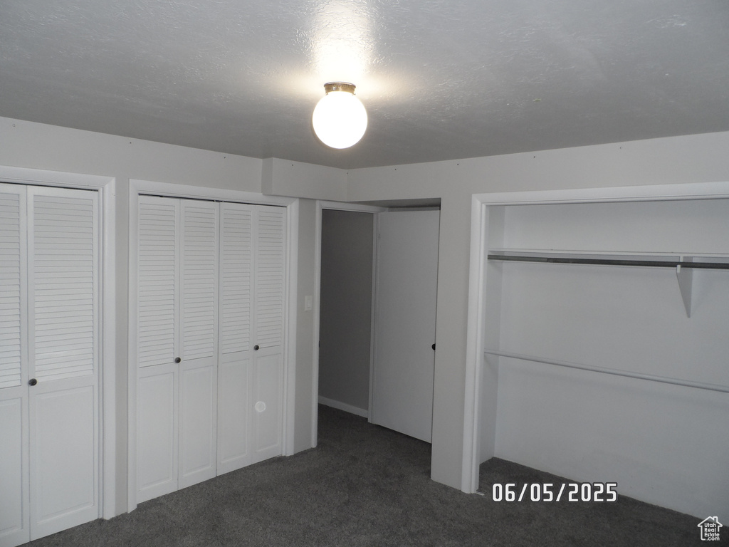 Unfurnished bedroom featuring carpet and multiple closets
