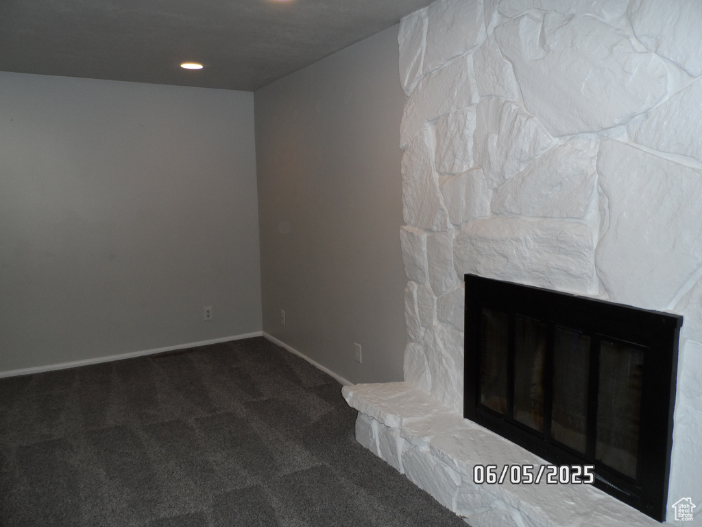 Unfurnished living room featuring carpet floors, a stone fireplace, baseboards, and recessed lighting