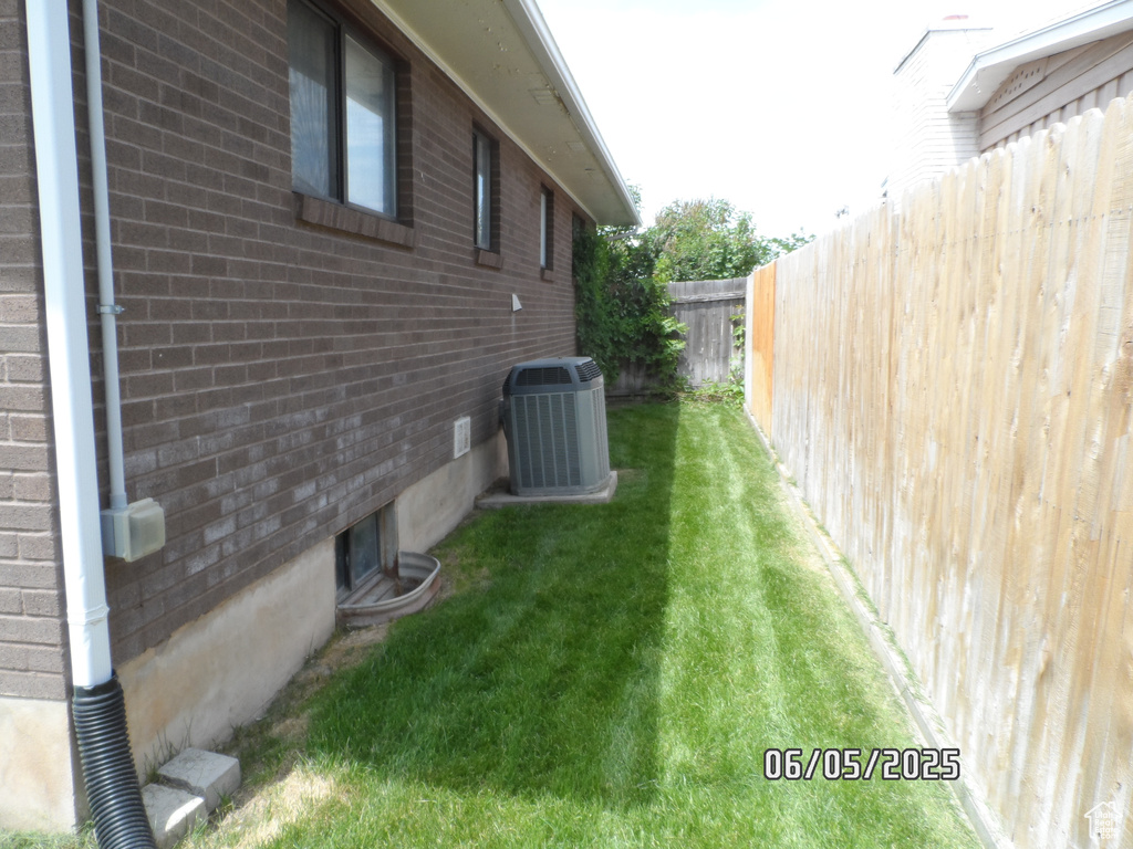 View of property exterior with central AC unit and brick siding