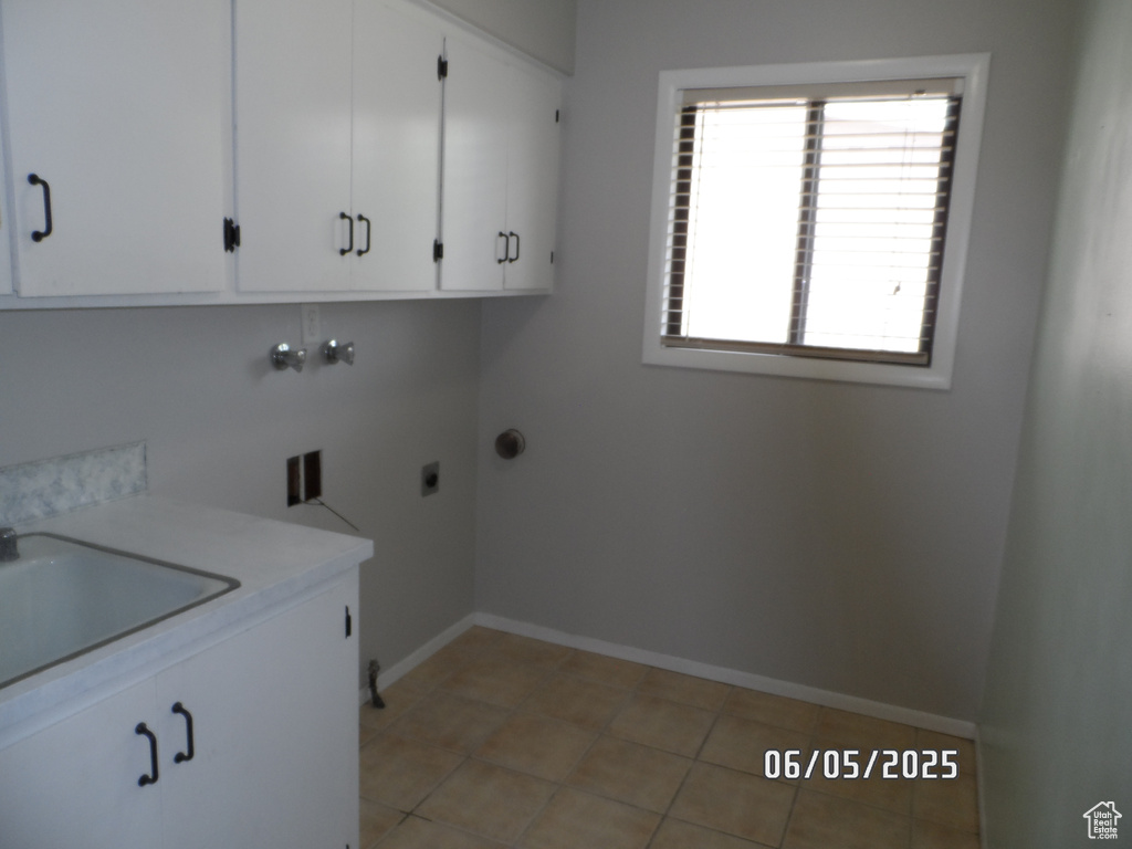 Laundry room with cabinet space, baseboards, hookup for an electric dryer, washer hookup, and light tile patterned floors