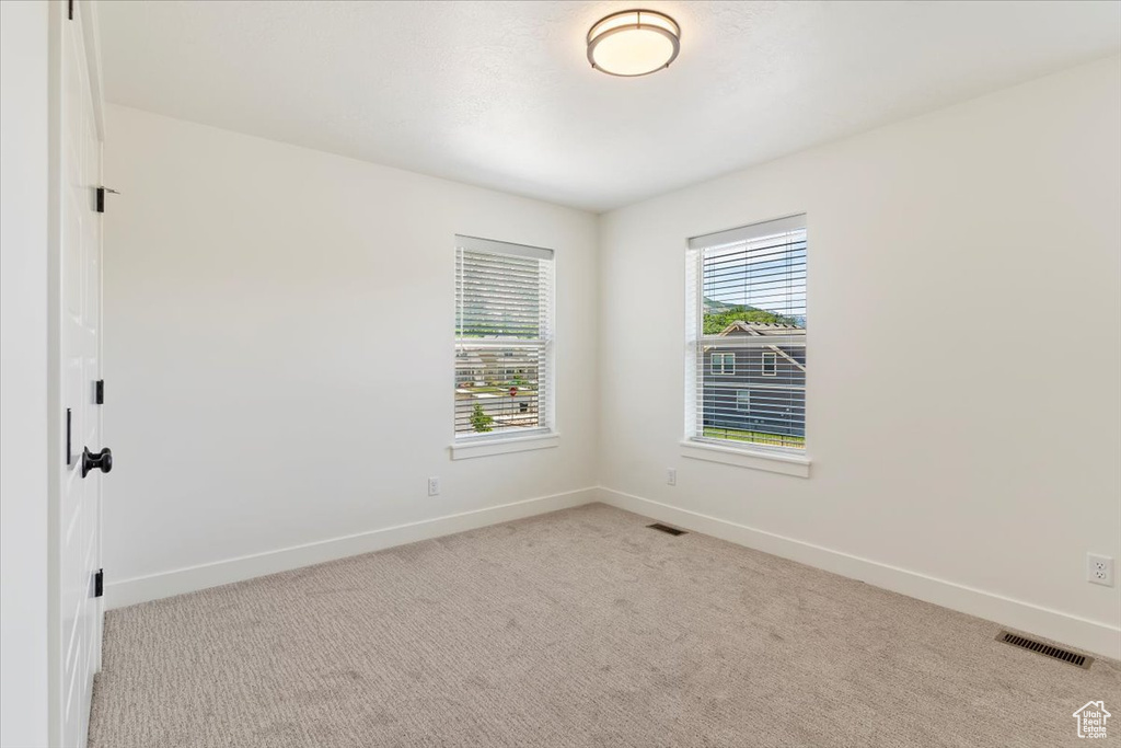 Carpeted spare room with baseboards
