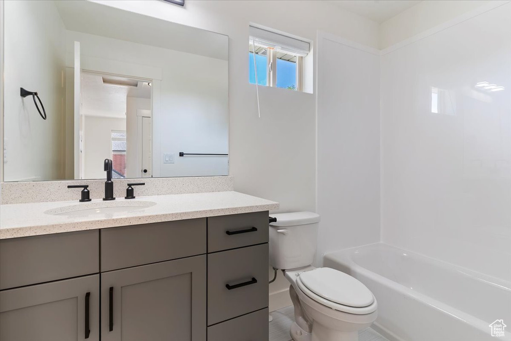 Full bath featuring toilet, vanity, and shower / bath combination