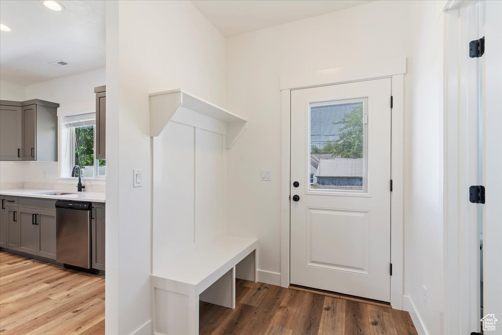 Mudroom with a sink, light wood-style flooring, recessed lighting, and baseboards