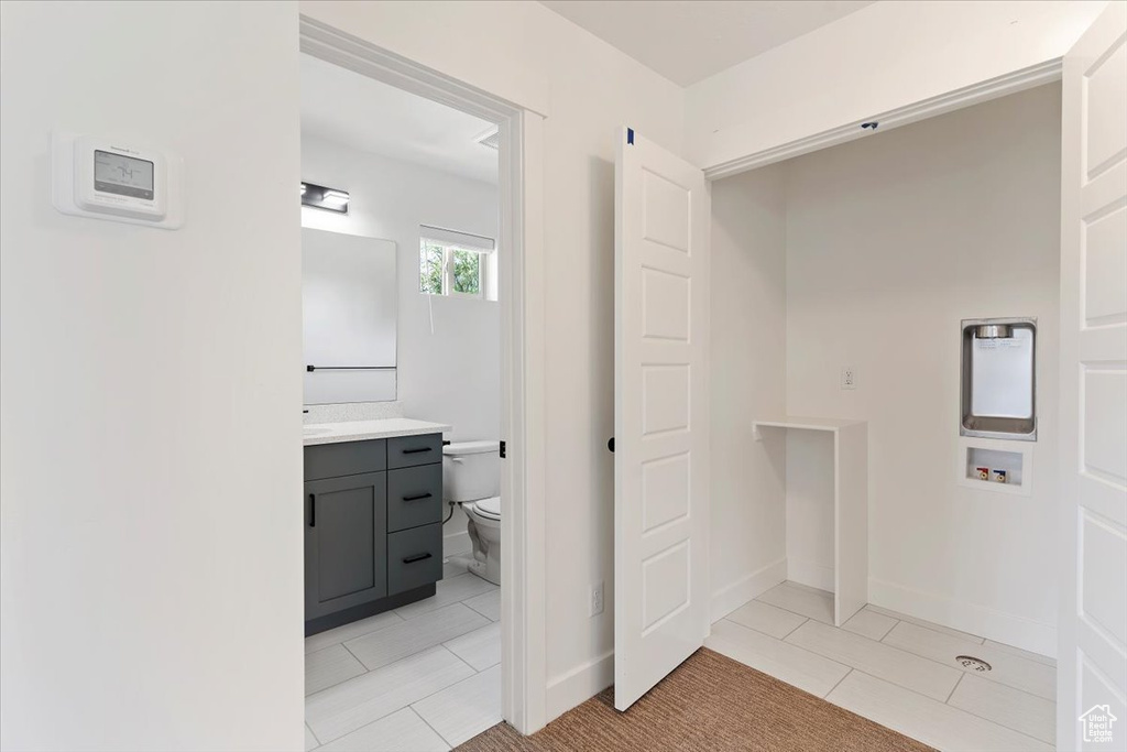 Bathroom with vanity, tile patterned floors, toilet, and baseboards