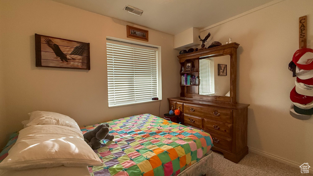 Bedroom featuring light carpet and baseboards