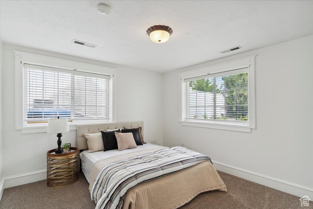 Bedroom featuring carpet and baseboards