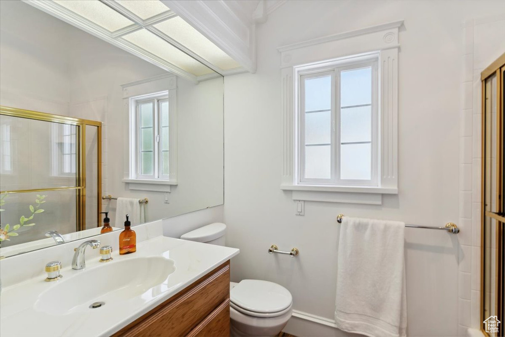 Full bath with plenty of natural light, toilet, tiled shower, and vanity