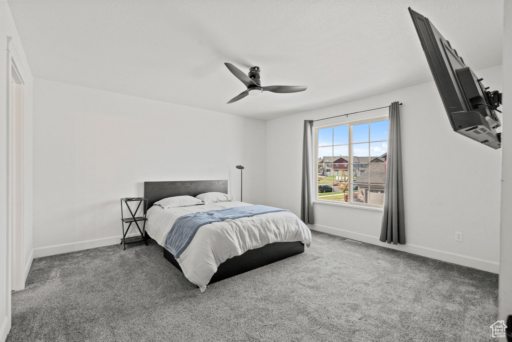 Carpeted bedroom with baseboards and a ceiling fan