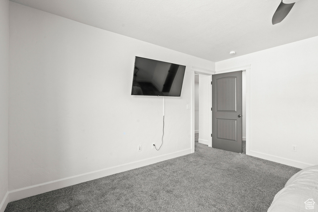 Unfurnished bedroom featuring carpet flooring, baseboards, and ceiling fan