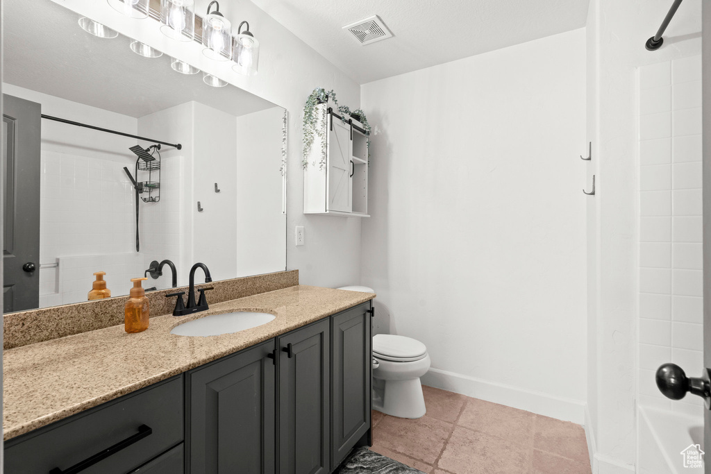 Bathroom with vanity, toilet, tub / shower combination, and baseboards