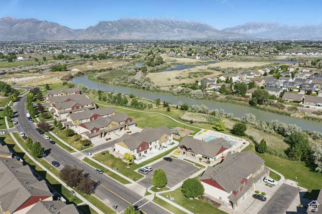 Aerial view of property's location with a water and mountain view and nearby suburban area