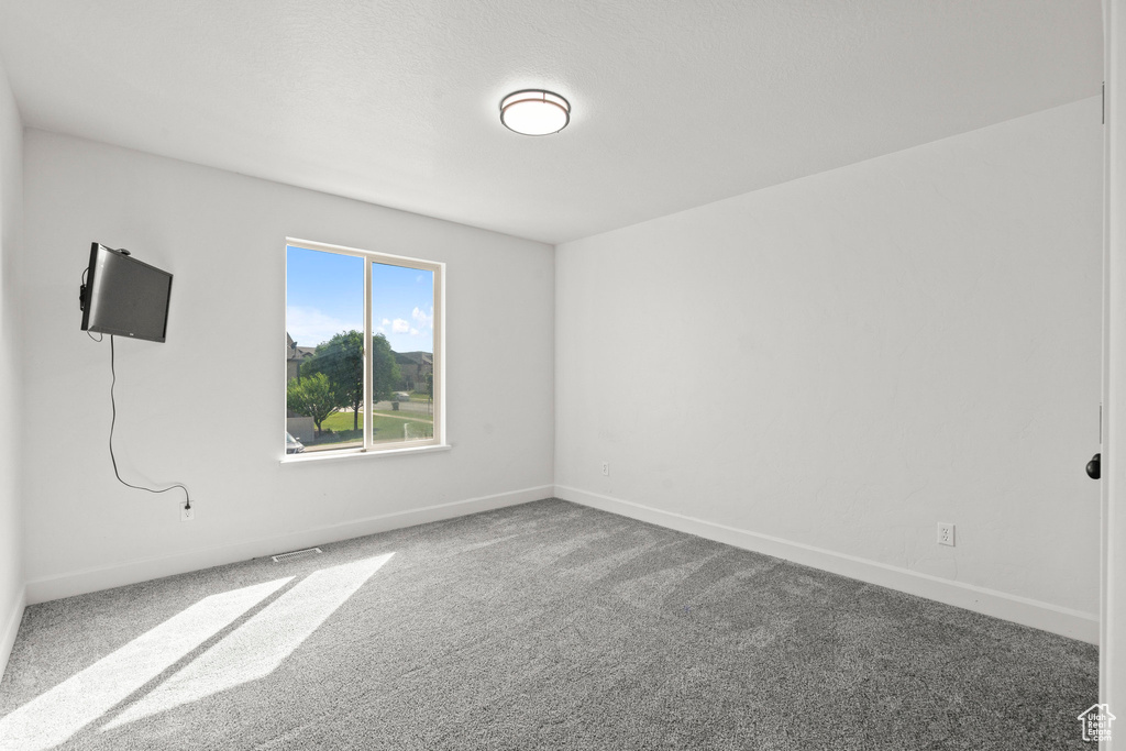 Carpeted empty room featuring baseboards