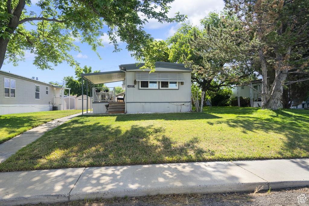Manufactured / mobile home featuring a front yard and central air condition unit