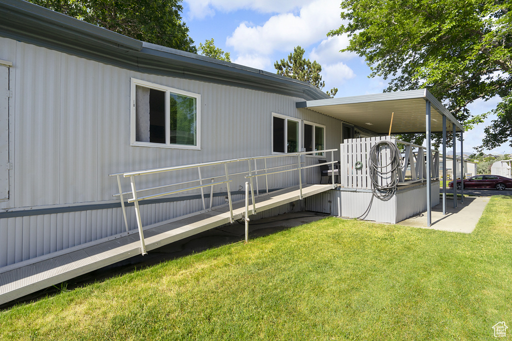 Rear view of house with a yard and a deck