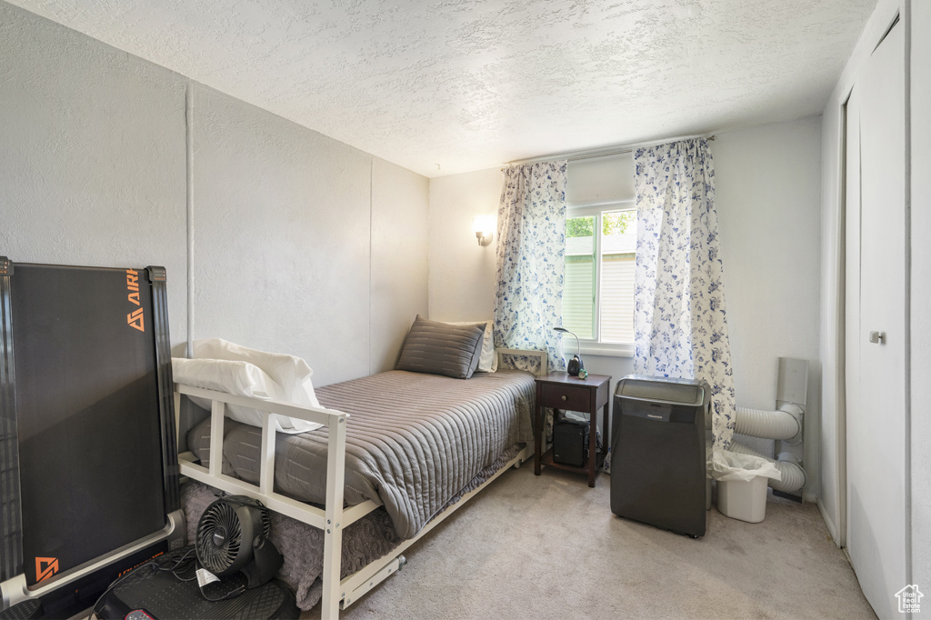 Bedroom featuring a textured ceiling and carpet flooring