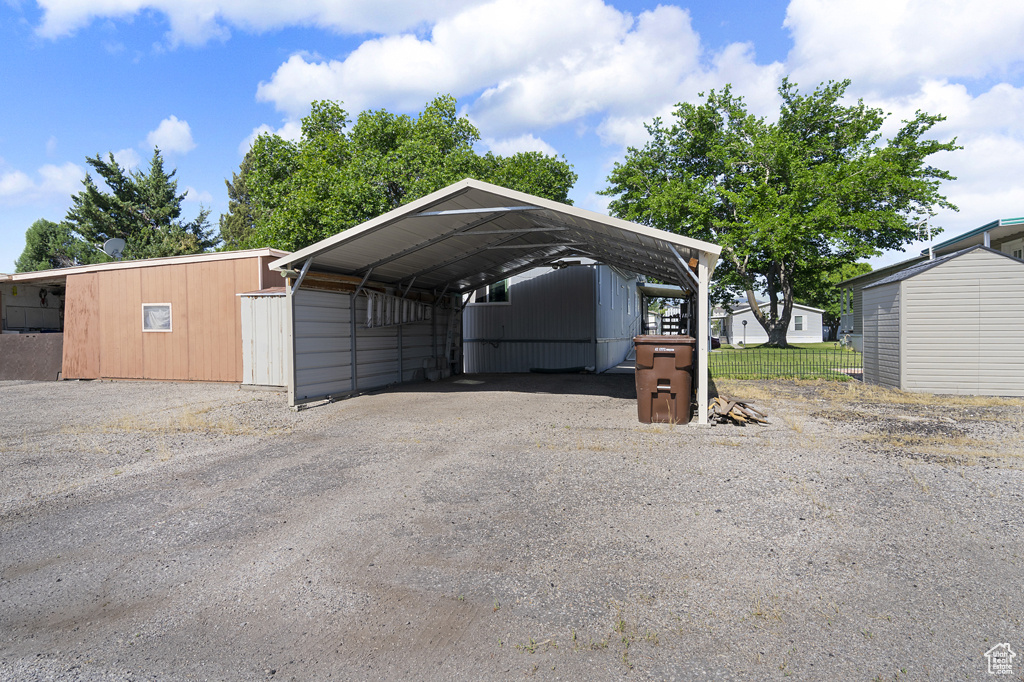 View of parking / parking lot with driveway and a detached carport