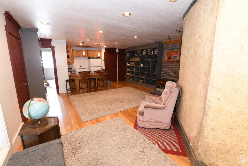 Living area featuring light wood finished floors and recessed lighting
