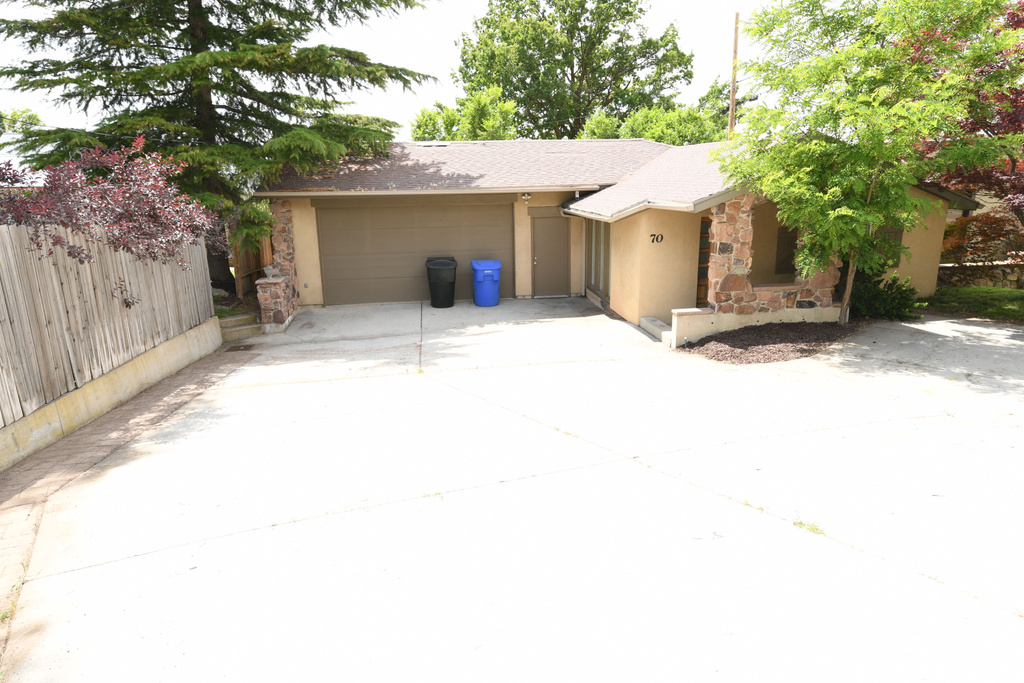 Ranch-style house with a garage, stucco siding, concrete driveway, a shingled roof, and stone siding