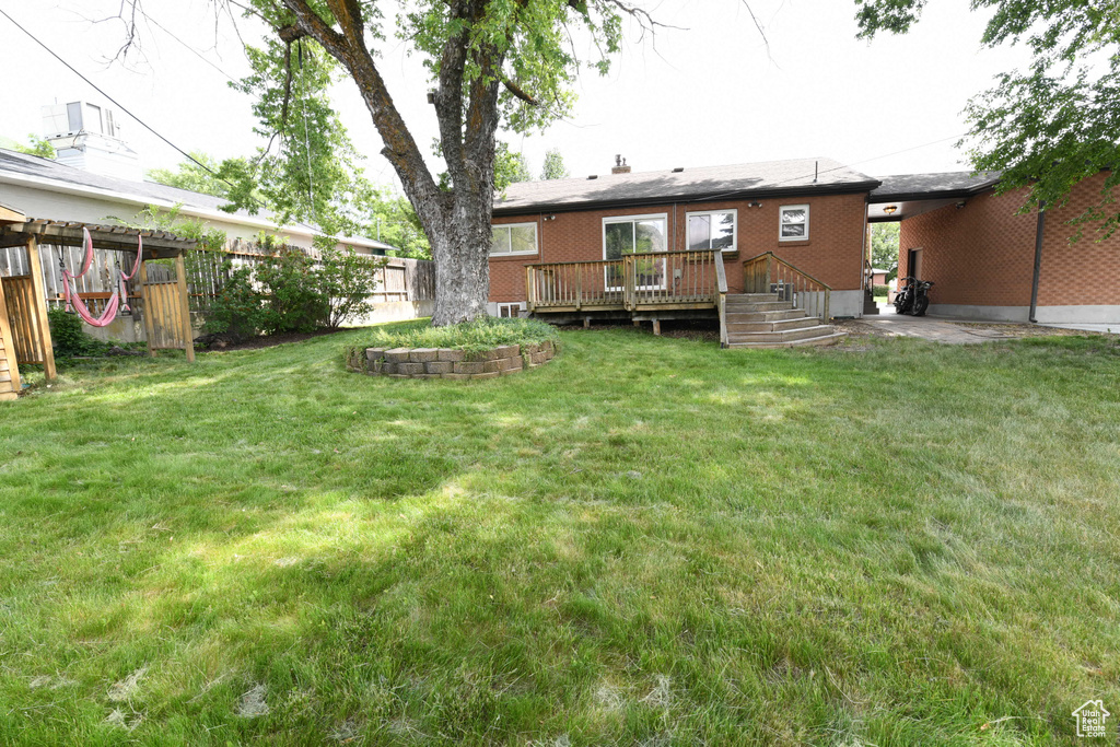 Back of house featuring a deck and brick siding