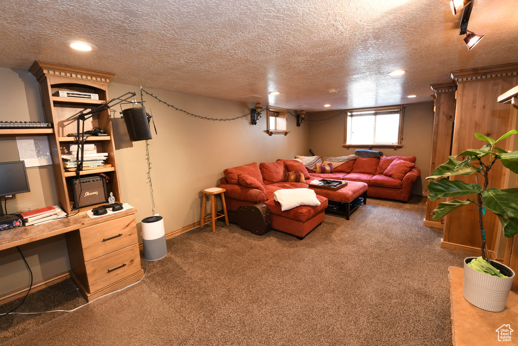 Carpeted living area with a textured ceiling, recessed lighting, and an office area