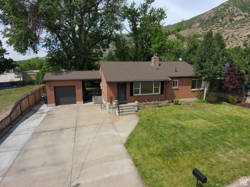 Single story home featuring brick siding, an attached garage, driveway, a chimney, and roof with shingles