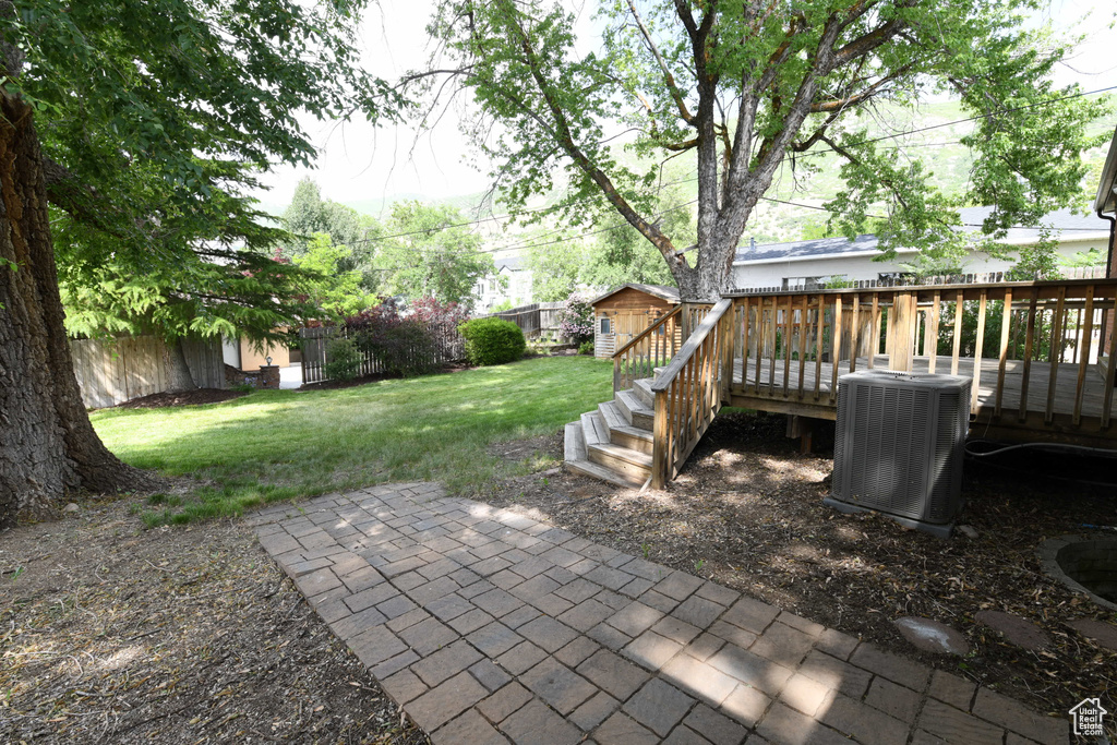 View of yard featuring cooling unit and a wooden deck