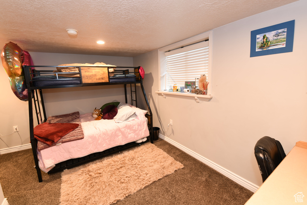 Carpeted bedroom featuring a textured ceiling, baseboards, and recessed lighting