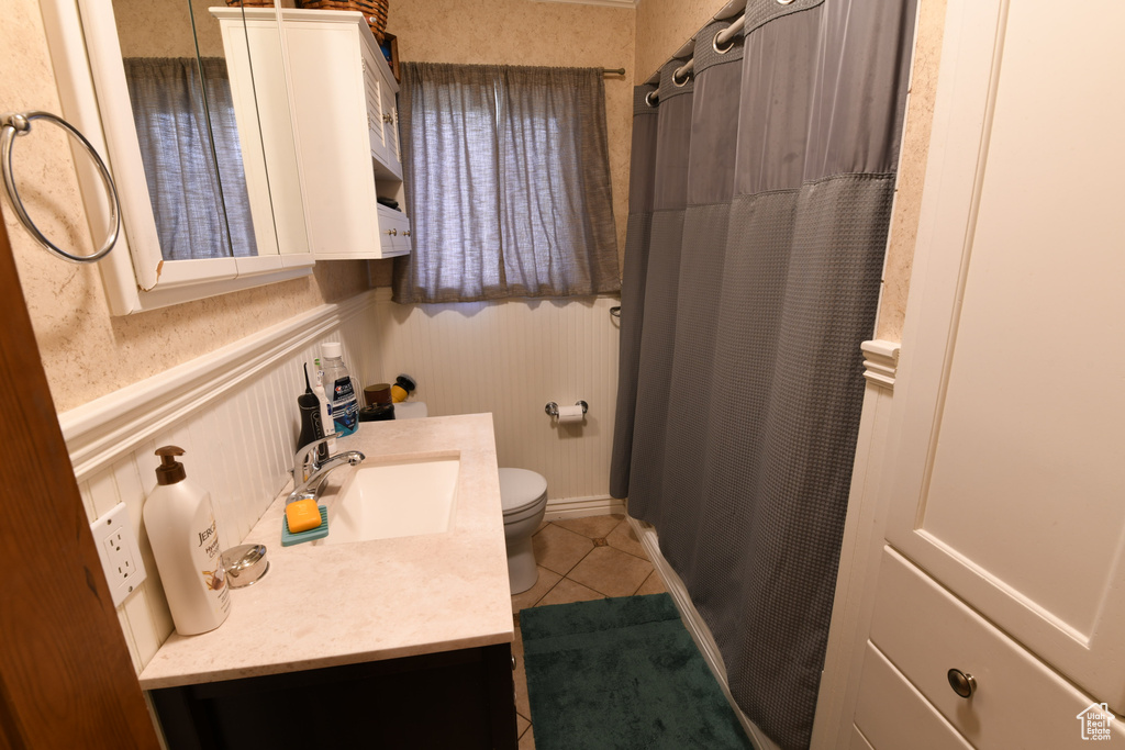 Full bathroom featuring vanity, toilet, tile patterned floors, and curtained shower