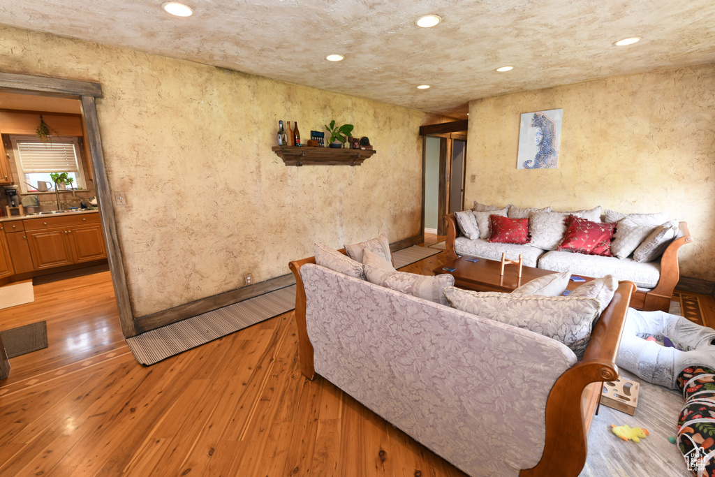 Living room featuring light wood-type flooring, recessed lighting, and baseboards