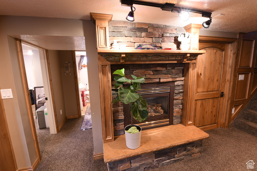 Detailed view of carpet, a textured ceiling, and a fireplace