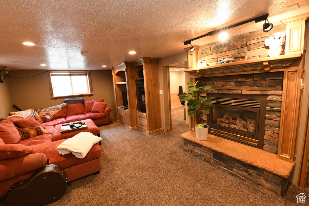 Living room featuring a textured ceiling, carpet floors, recessed lighting, and a fireplace