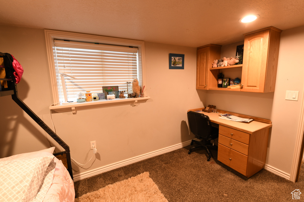 Carpeted office with baseboards, built in desk, and recessed lighting