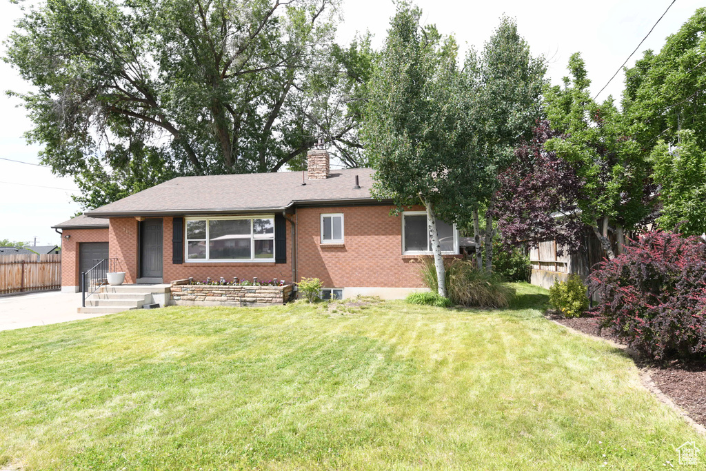 Single story home with a garage, a chimney, brick siding, and driveway