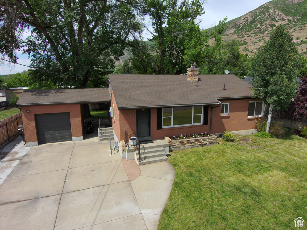Single story home featuring an attached garage, driveway, brick siding, and a chimney