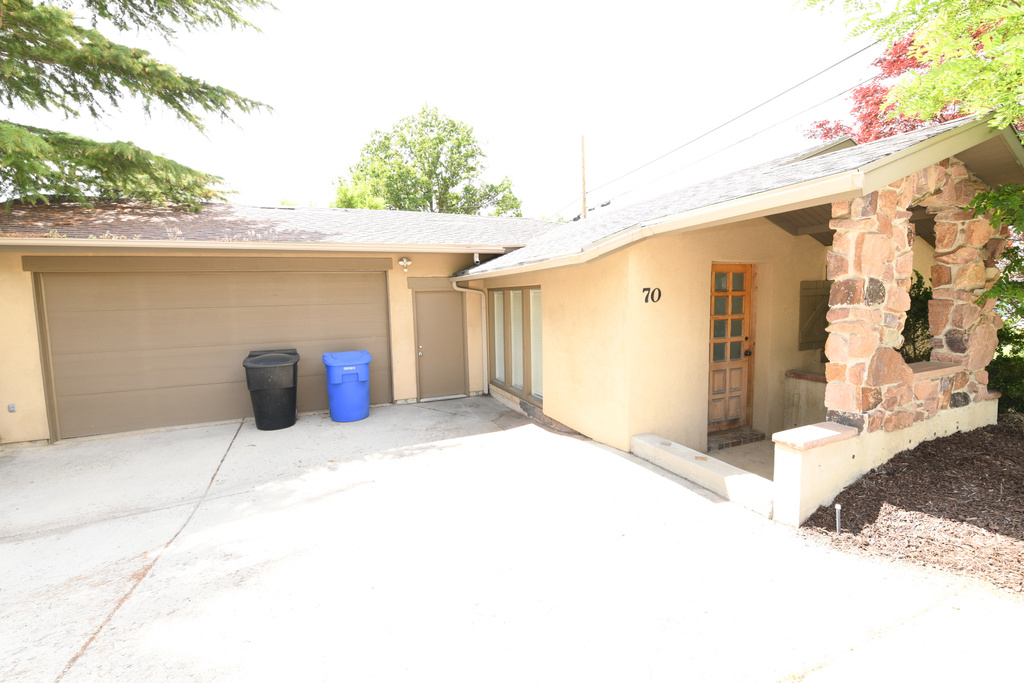 View of property exterior with stucco siding and driveway