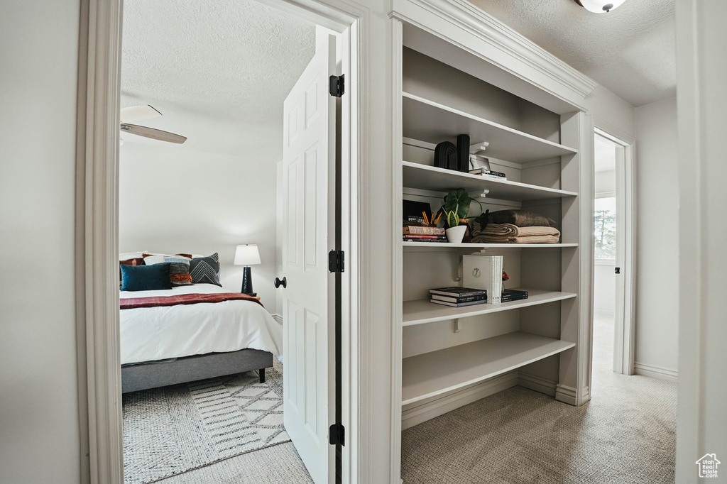 Bedroom with carpet floors, a textured ceiling, and baseboards
