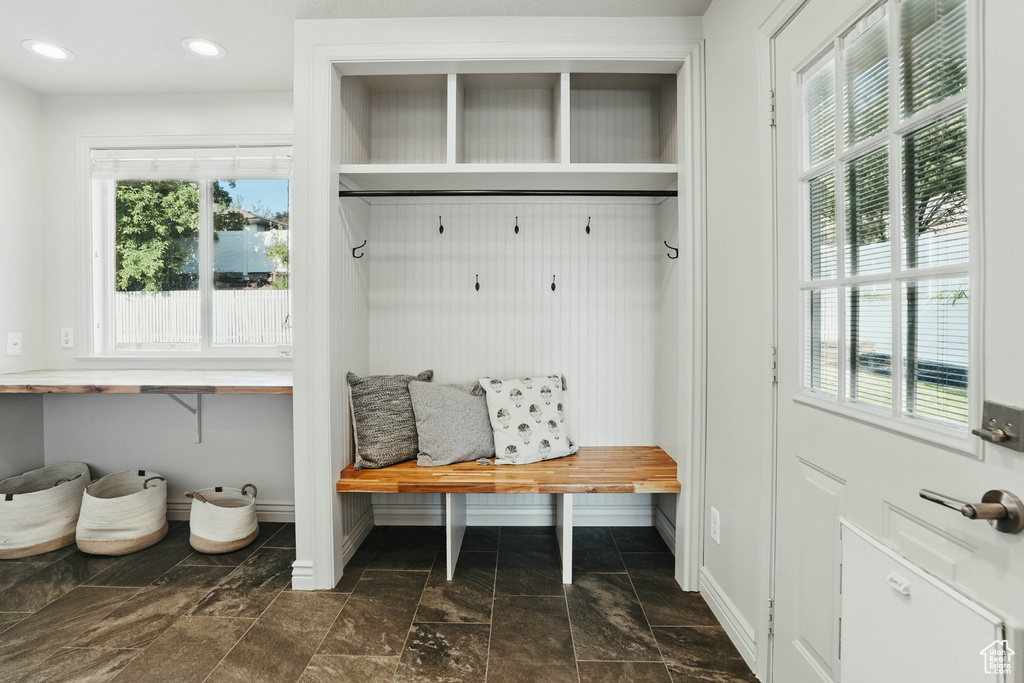 Mudroom with plenty of natural light, baseboards, dark stone finish flooring, and recessed lighting