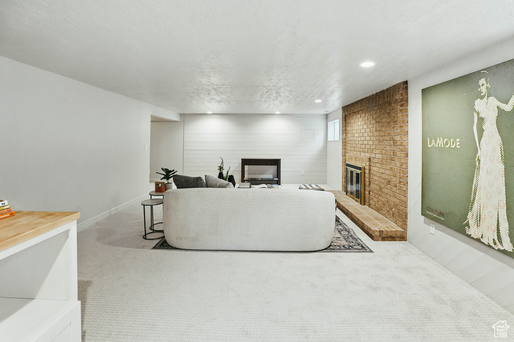 Living room with a fireplace, carpet floors, recessed lighting, and baseboards