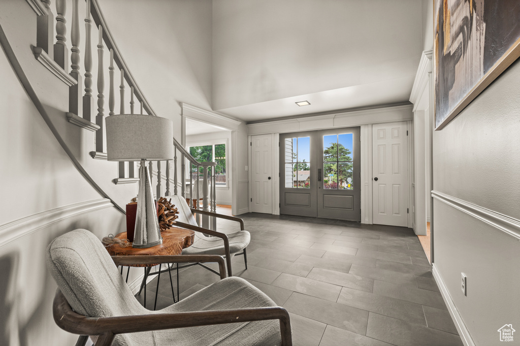 Entrance foyer featuring stairs, a high ceiling, baseboards, and tile patterned floors