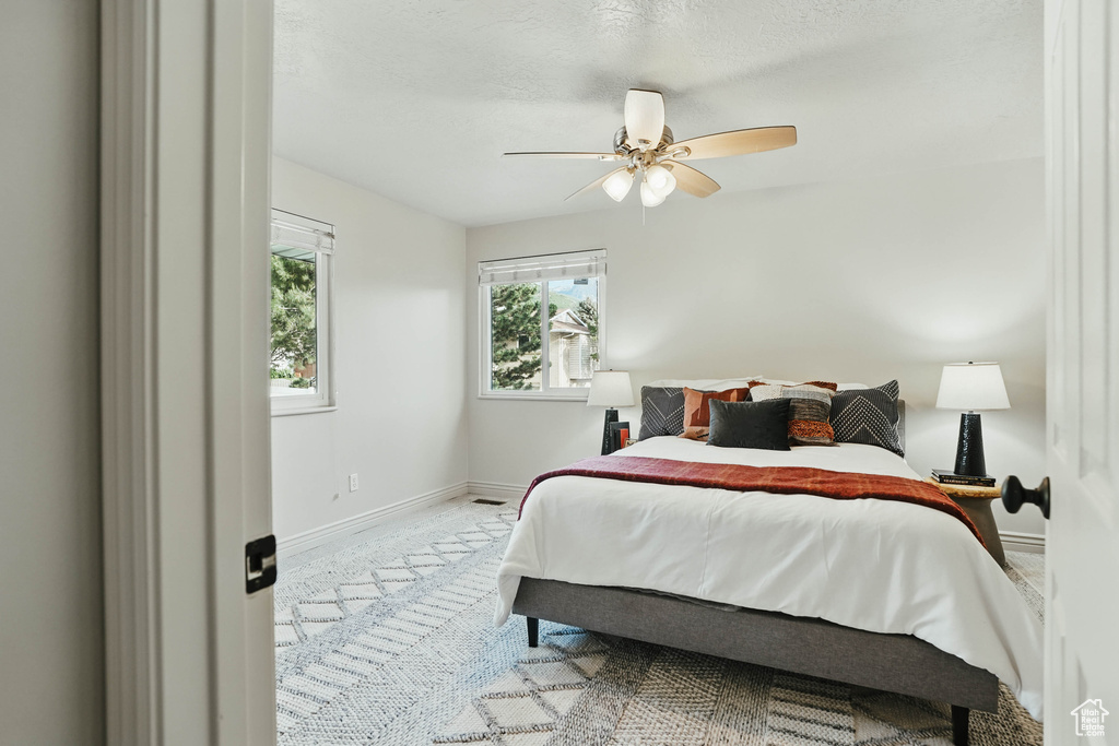 Carpeted bedroom with baseboards and a ceiling fan